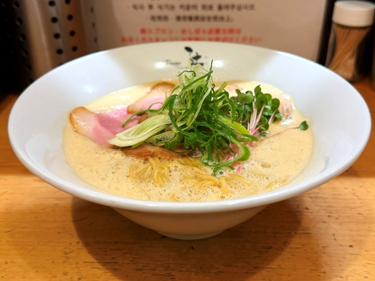 ラーメン 辻 の鶏白湯（醤油）。縁に「辻」の入った白い器に、チャーシューとねぎ